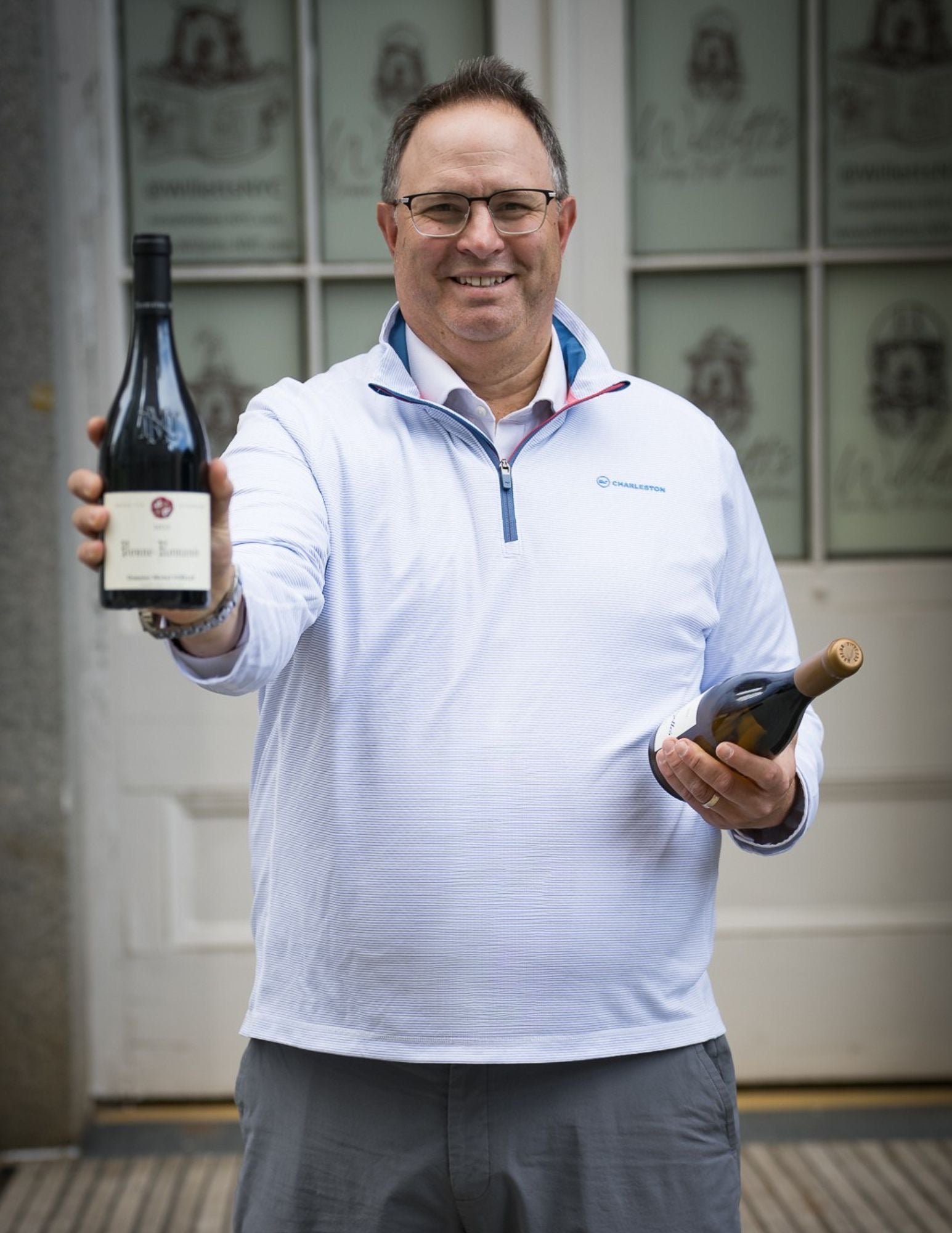 Daniel Posner holding two bottles of wine
